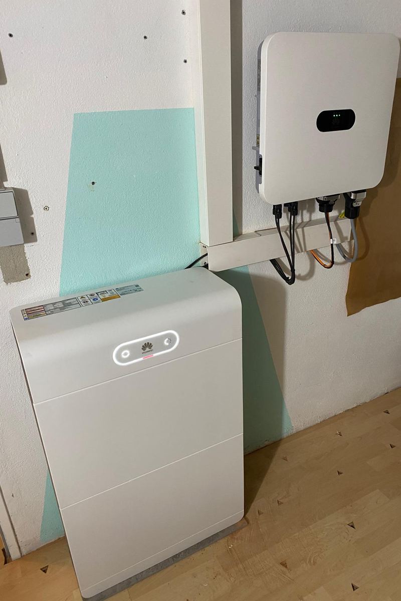 Wechselrichter und Batteriespeicher an einer Innenwand, Leitungen im Kabelkanal